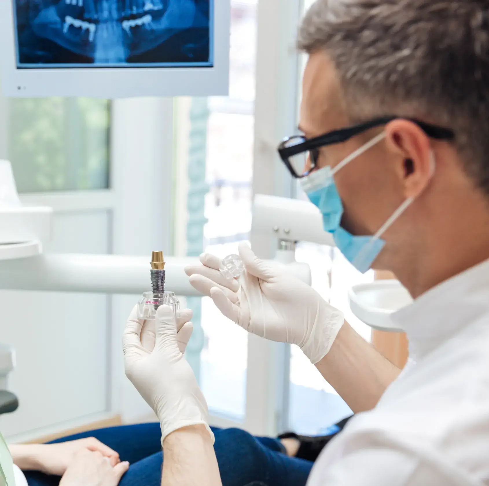 A dentist examines a patient's teeth in a dental office.