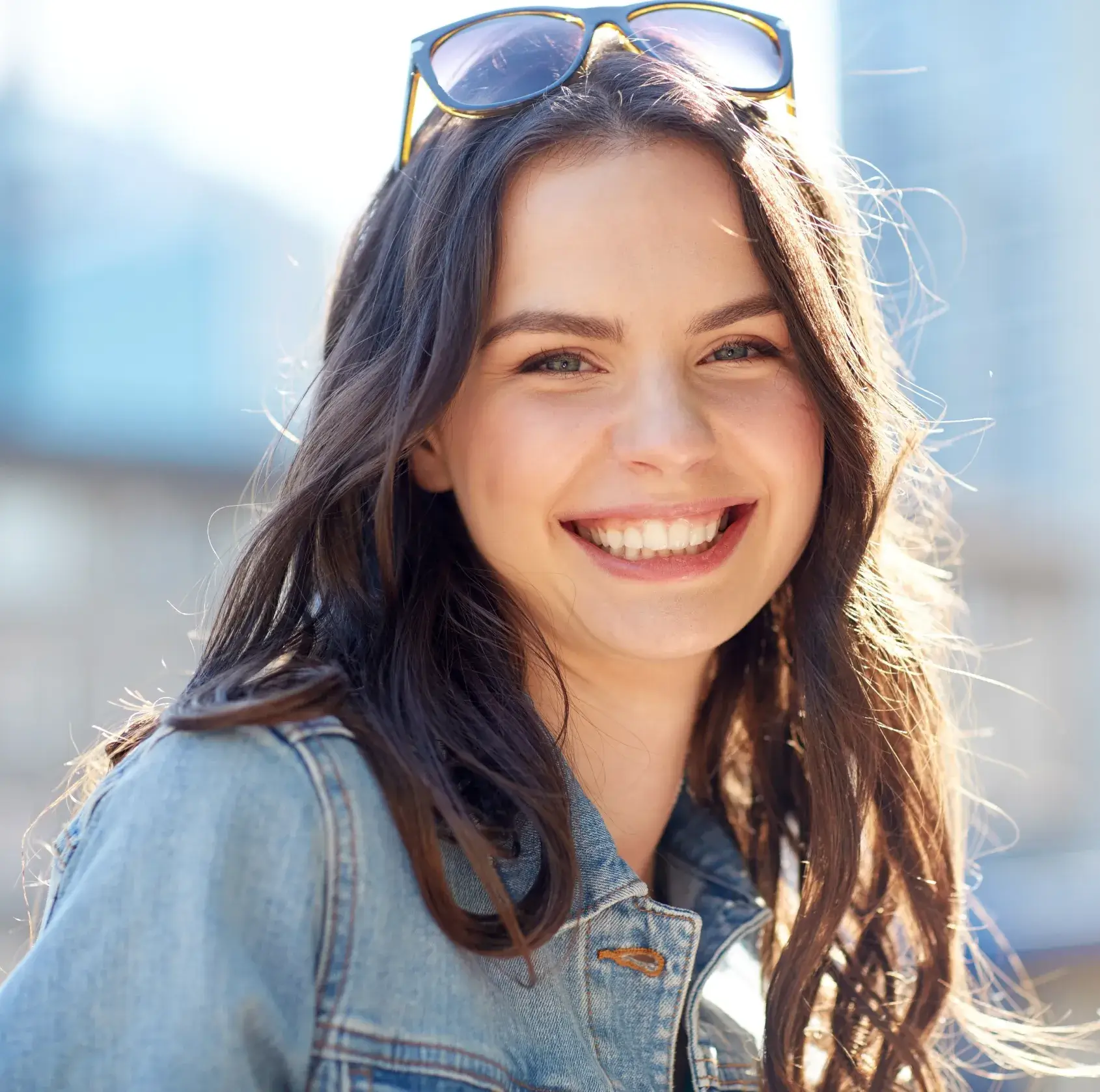 A woman wearing sunglasses and smiling for the camera.