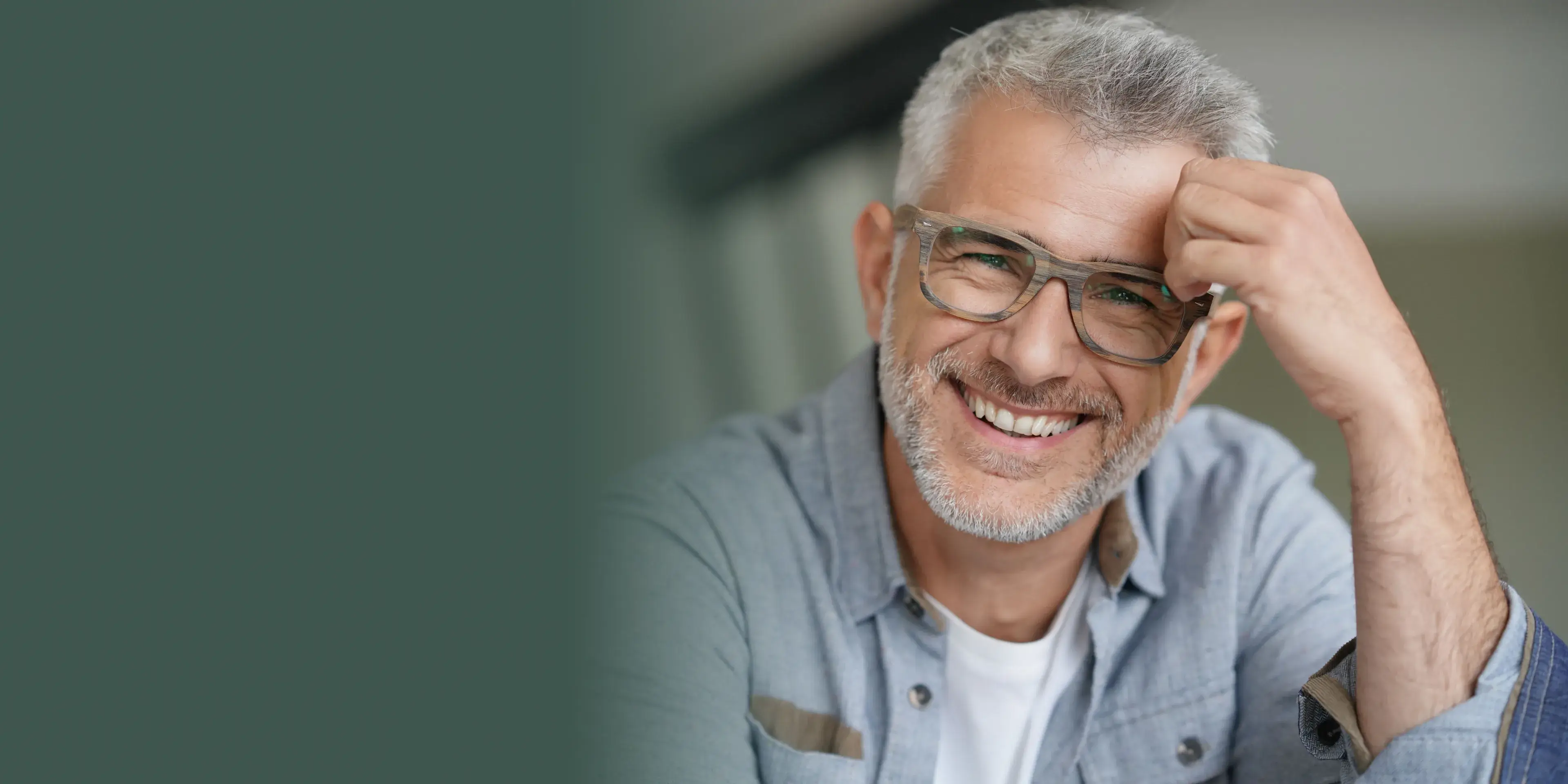 A smiling man wearing glasses and a blue shirt.