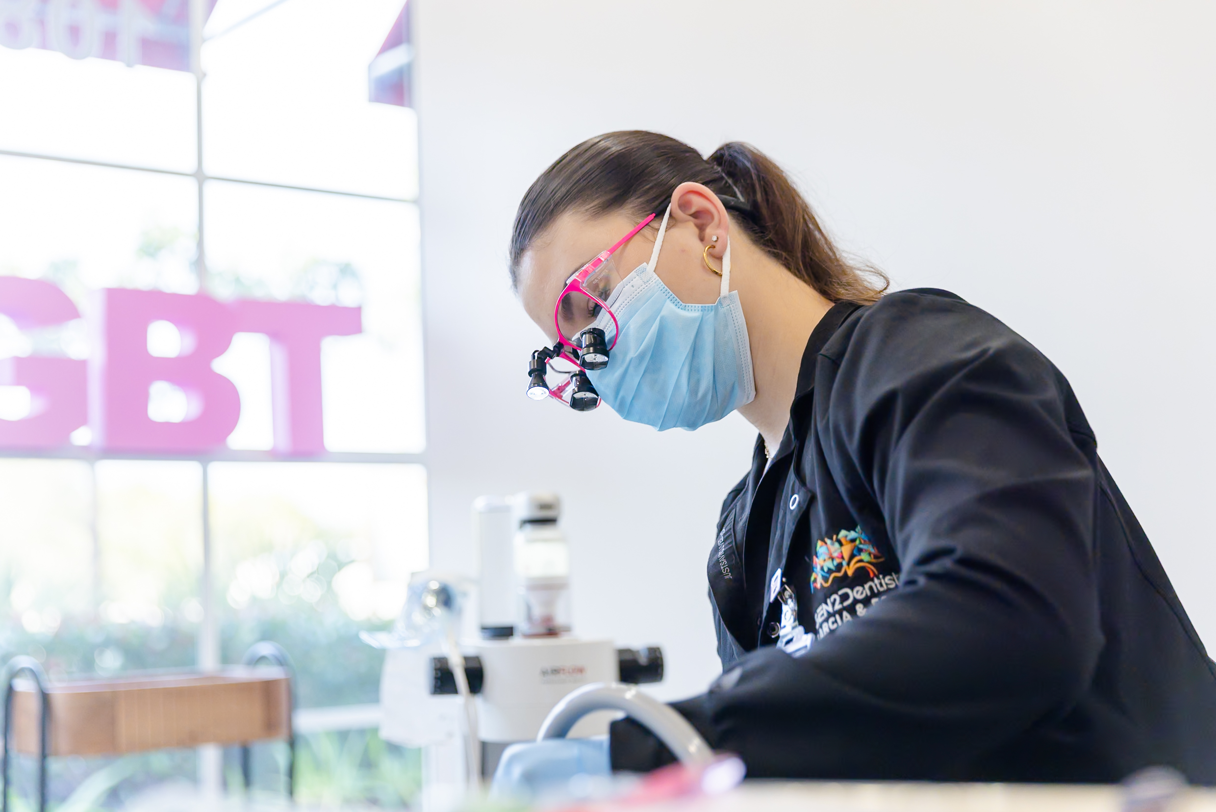 Hygienist providing precision dental treatment using magnification at Gen2 Dentistry in Davie, Florida.