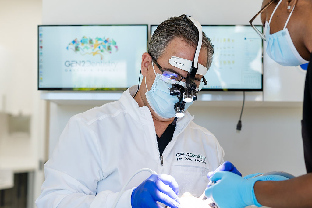 Dr. Paul Garcia providing dental treatment using magnification at Gen2 Dentistry in Davie, Florida.