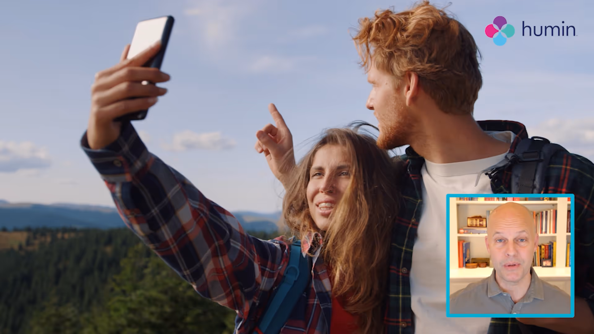 Man in shadow holding his head with hand wearing a ring, with a smaller inset video of a bald man speaking in front of a bookshelf.