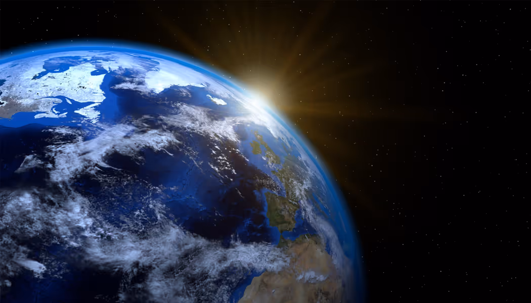 Sun rising over Earth showing Europe, part of Africa, and surrounding oceans against a starry space background.