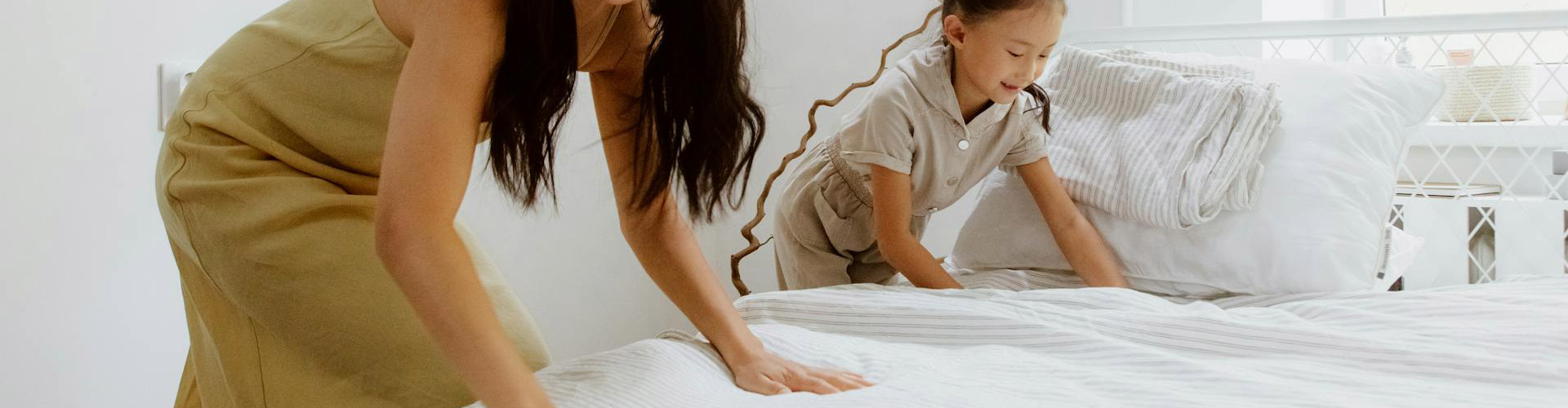 woman and child making a bed