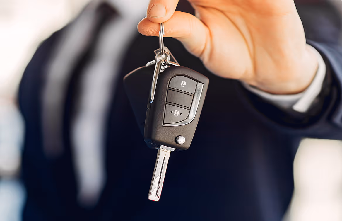 A man holding a car key in his hand.