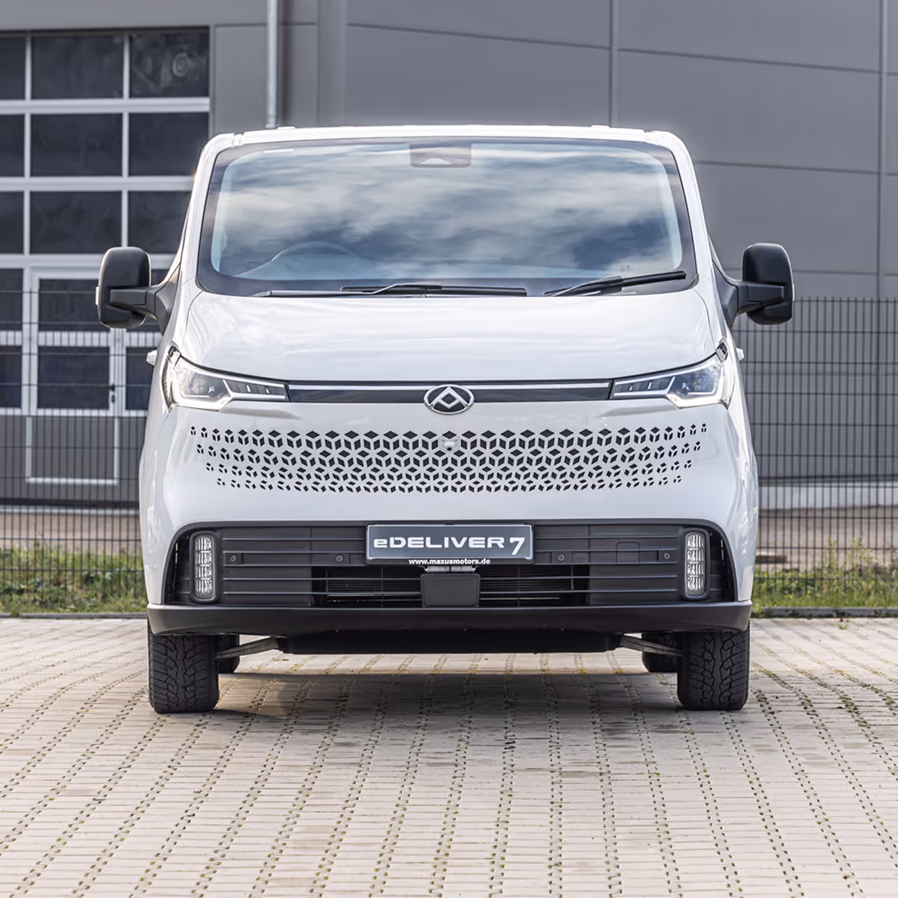 A white van parked in front of a building.