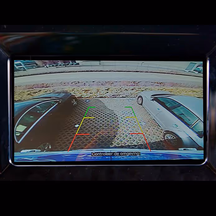 Rearview backup camera display showing two cars parked on either side with parking guide lines and a warning in Dutch to check surroundings.