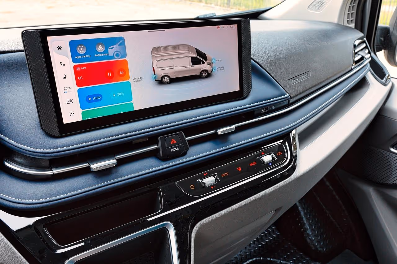 Dashboard interior of a vehicle featuring a wide touchscreen displaying vehicle settings, Apple CarPlay, and Android Auto options.