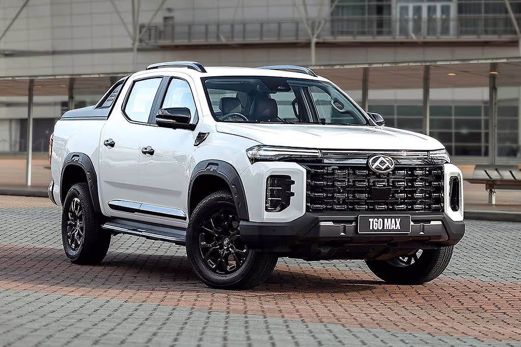 White T60 Max pickup truck parked on tiled pavement with modern building in the background.