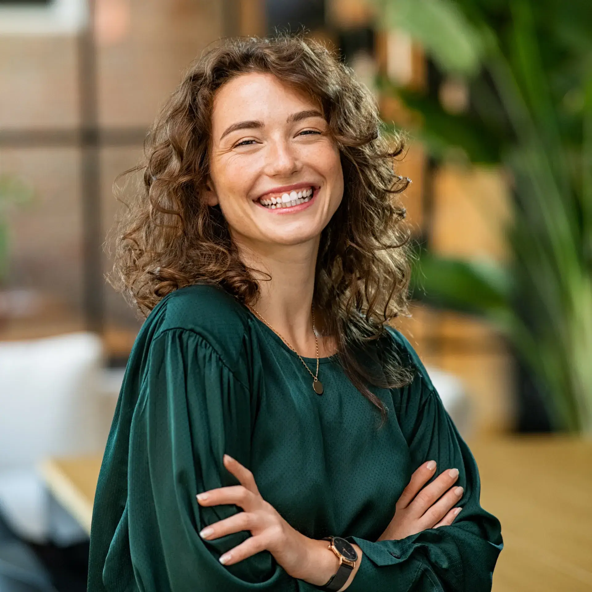 A woman with her arms crossed smiling.