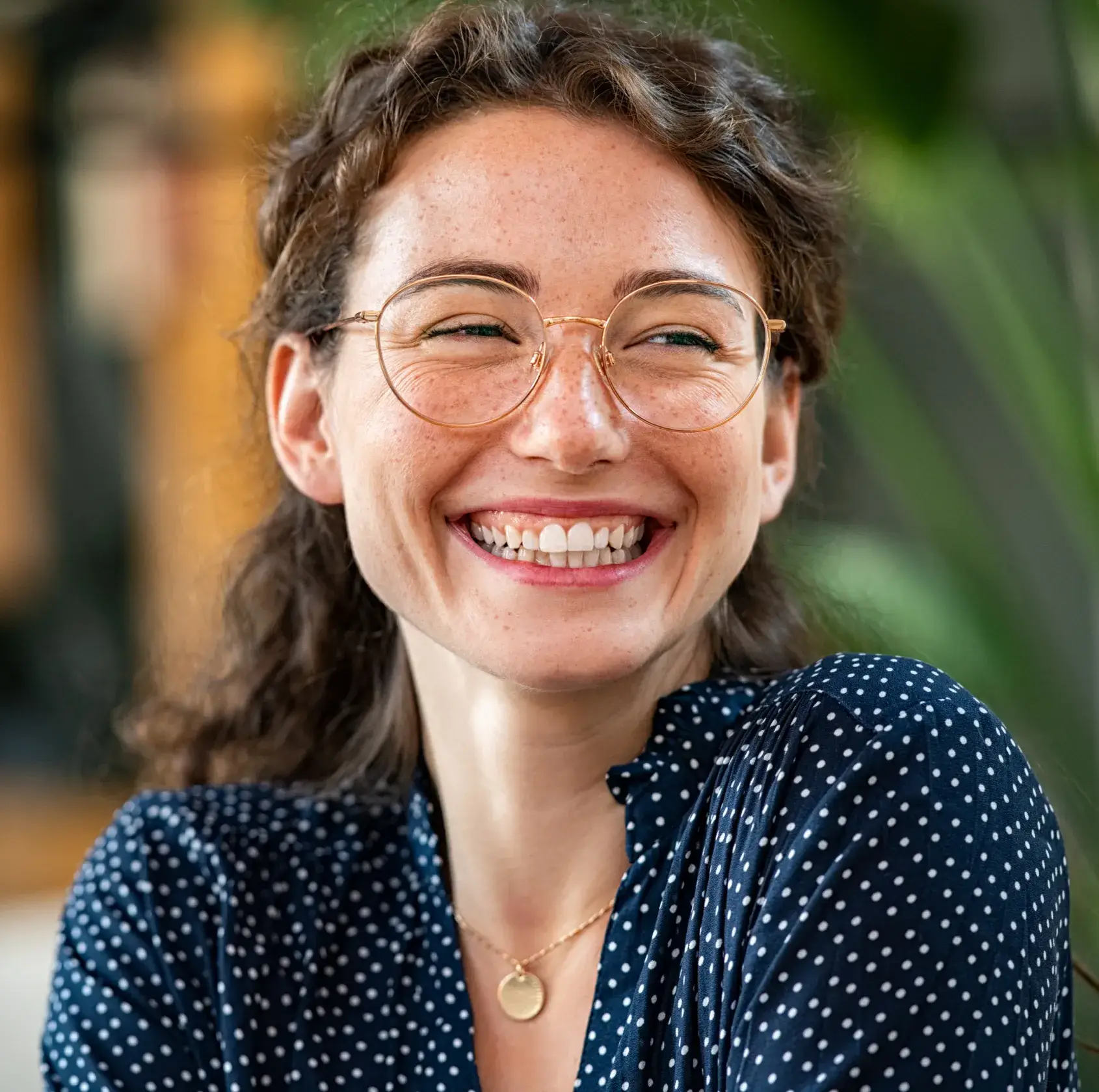 A woman with glasses smiling for the camera.