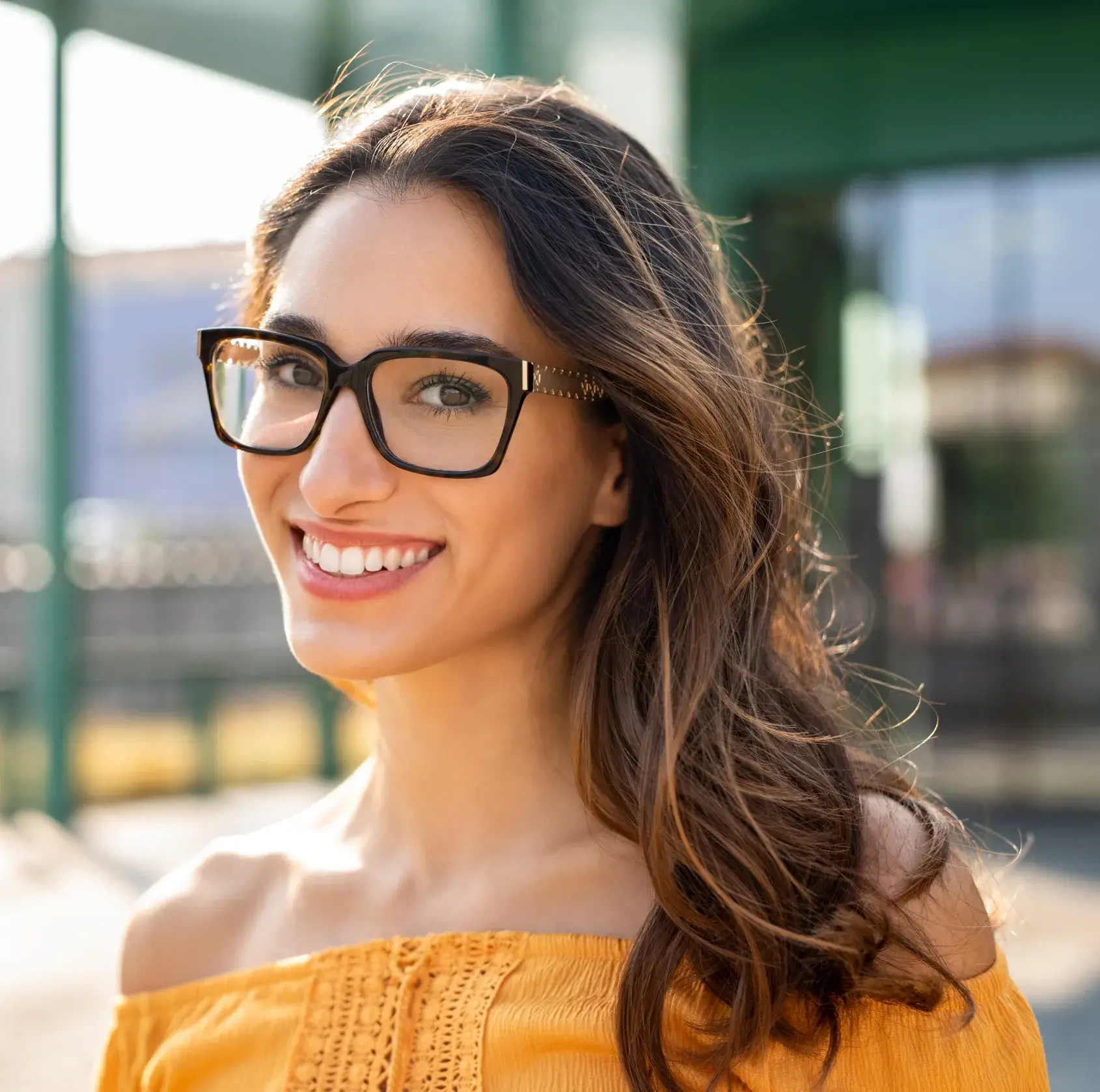 A woman wearing glasses and smiling for the camera.