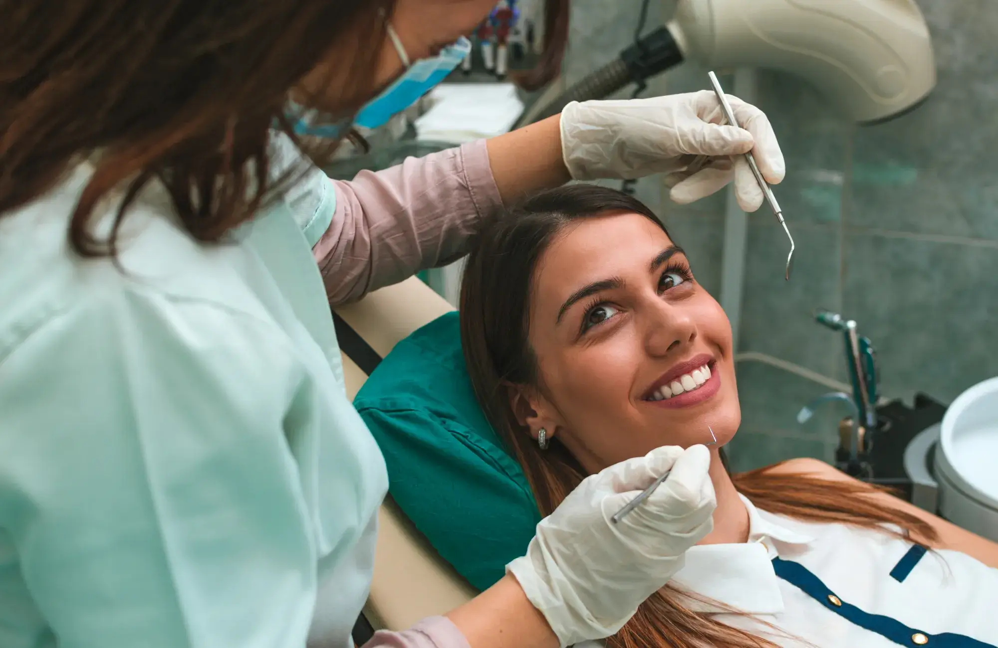 A woman getting her teeth checked by a dentist.