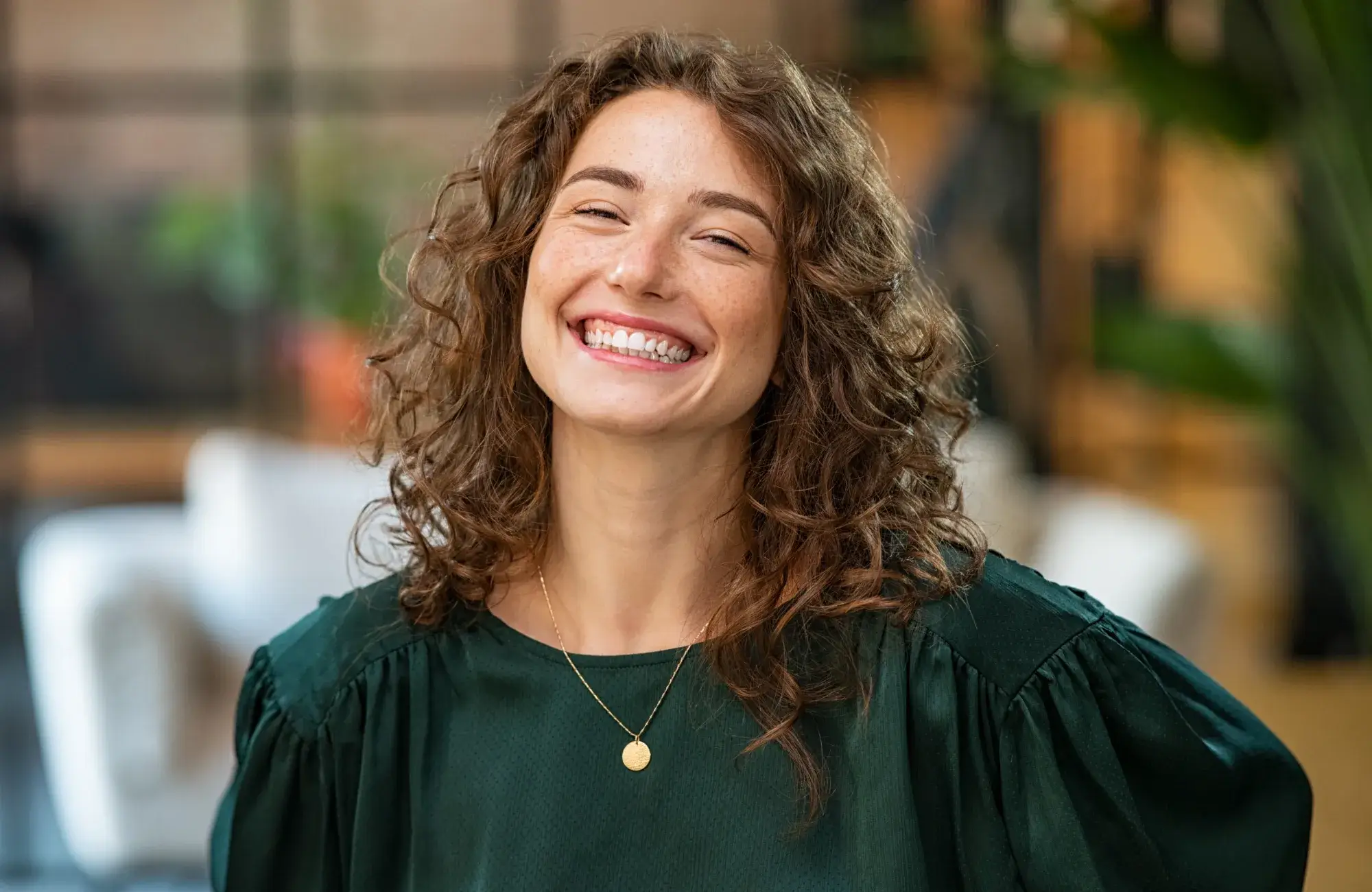 A smiling woman in a green top with a smile on her face.