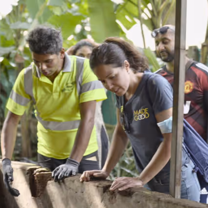 Group of people observing a waste management or recycling process at a rePurpose Global impact project site.