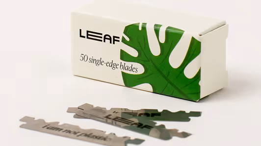 Box labeled 'LEAF' containing 50 single-edge blades with three blades laid out in front.