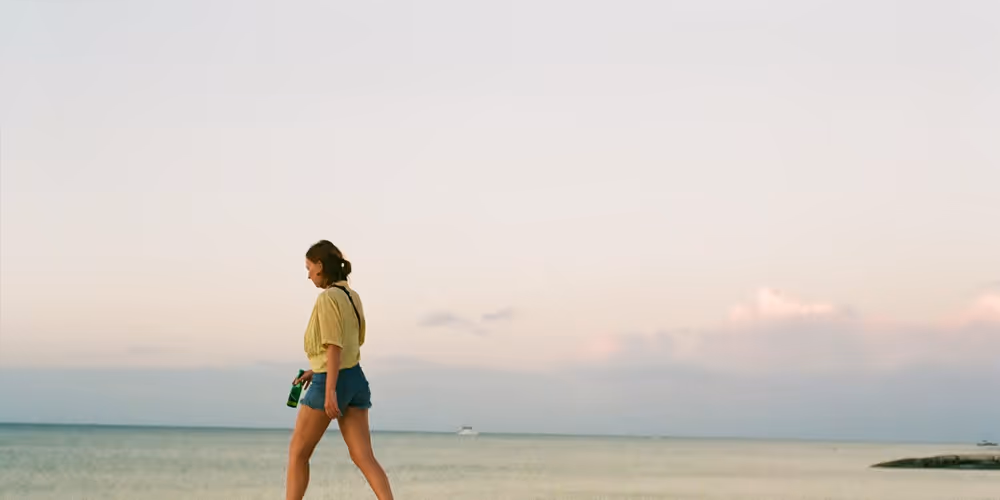 Fiona McVitie, a zero waste eco influencer walking on the beach