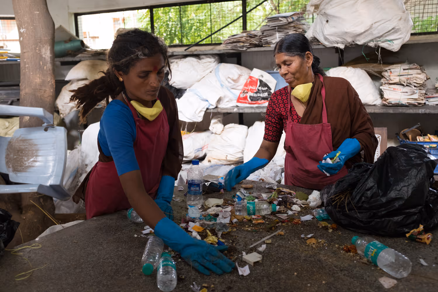 2 women sorting out waste at a recycling enterprise in India