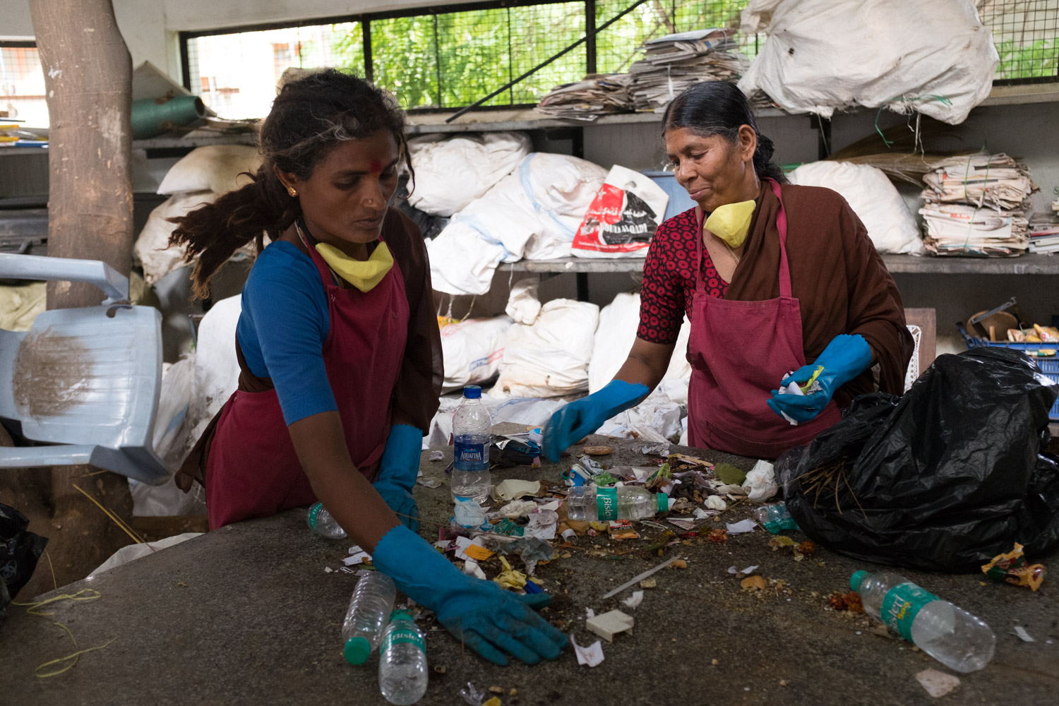 2 women sorting out waste at a recycling enterprise in India