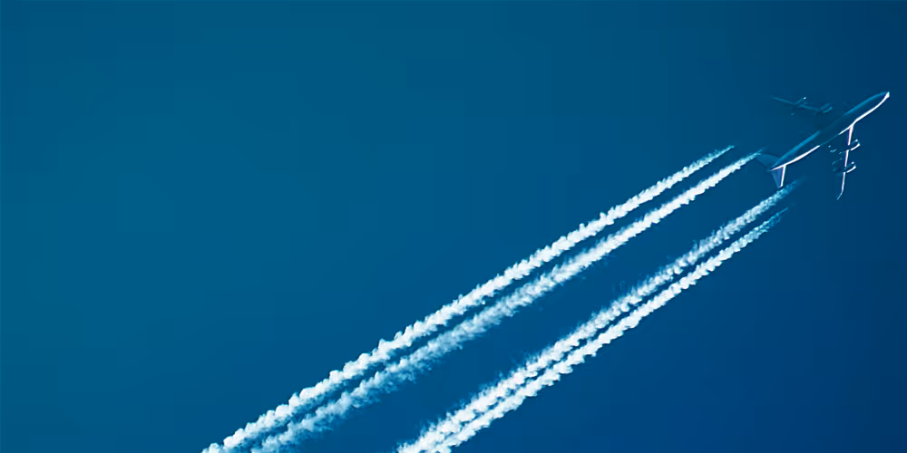 An airplane in the sky with a jetstream