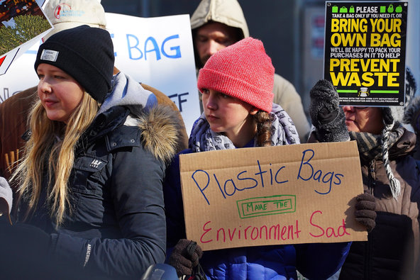 Girl holding up a poster saying"Plastic Bags Make the Environment Sad"