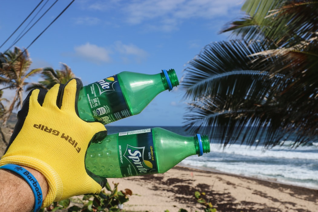 A pair of single use plastic bottles on a beach