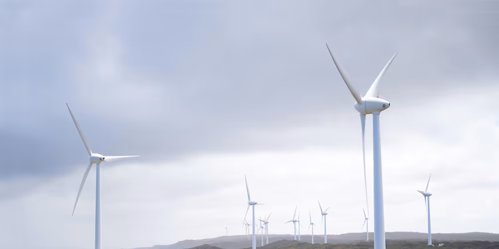 Rotating wind turbines with the backdrop of a grey sky