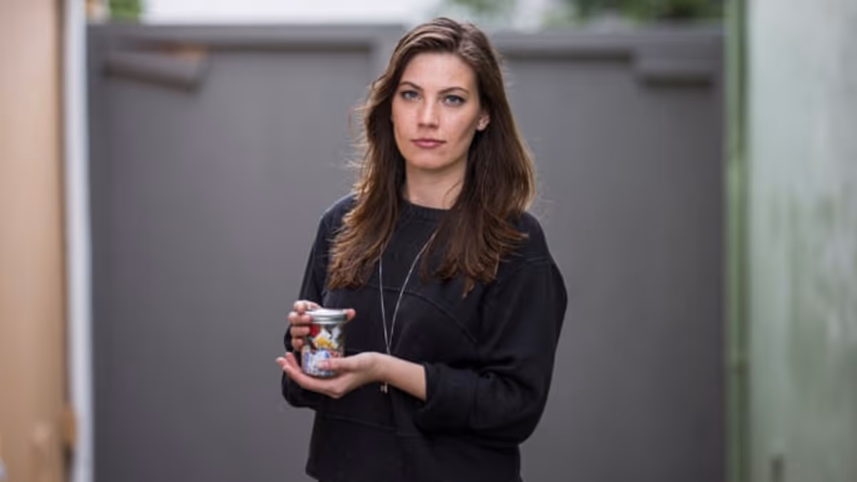 Kathryn Kellogg (Going Zero Waste) a zero-waste blogger holding a year's worth of trash in a small jar