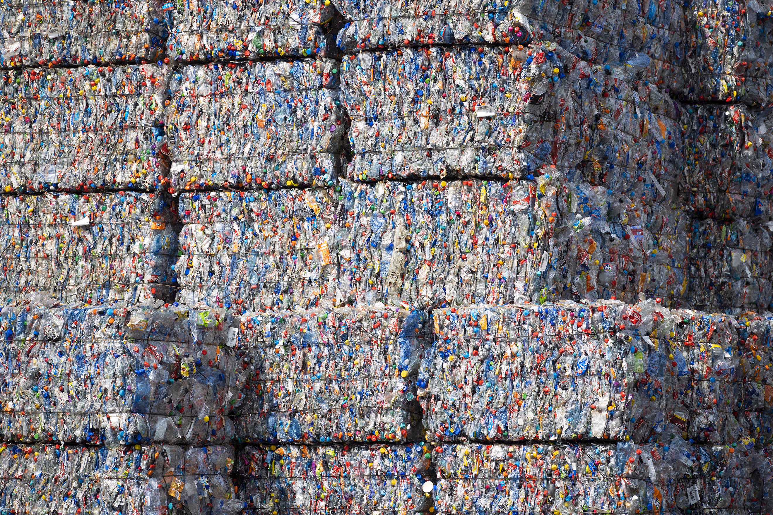 Bound bales of crushed plastic as part of developed countries exported wastewaiting to be recycled