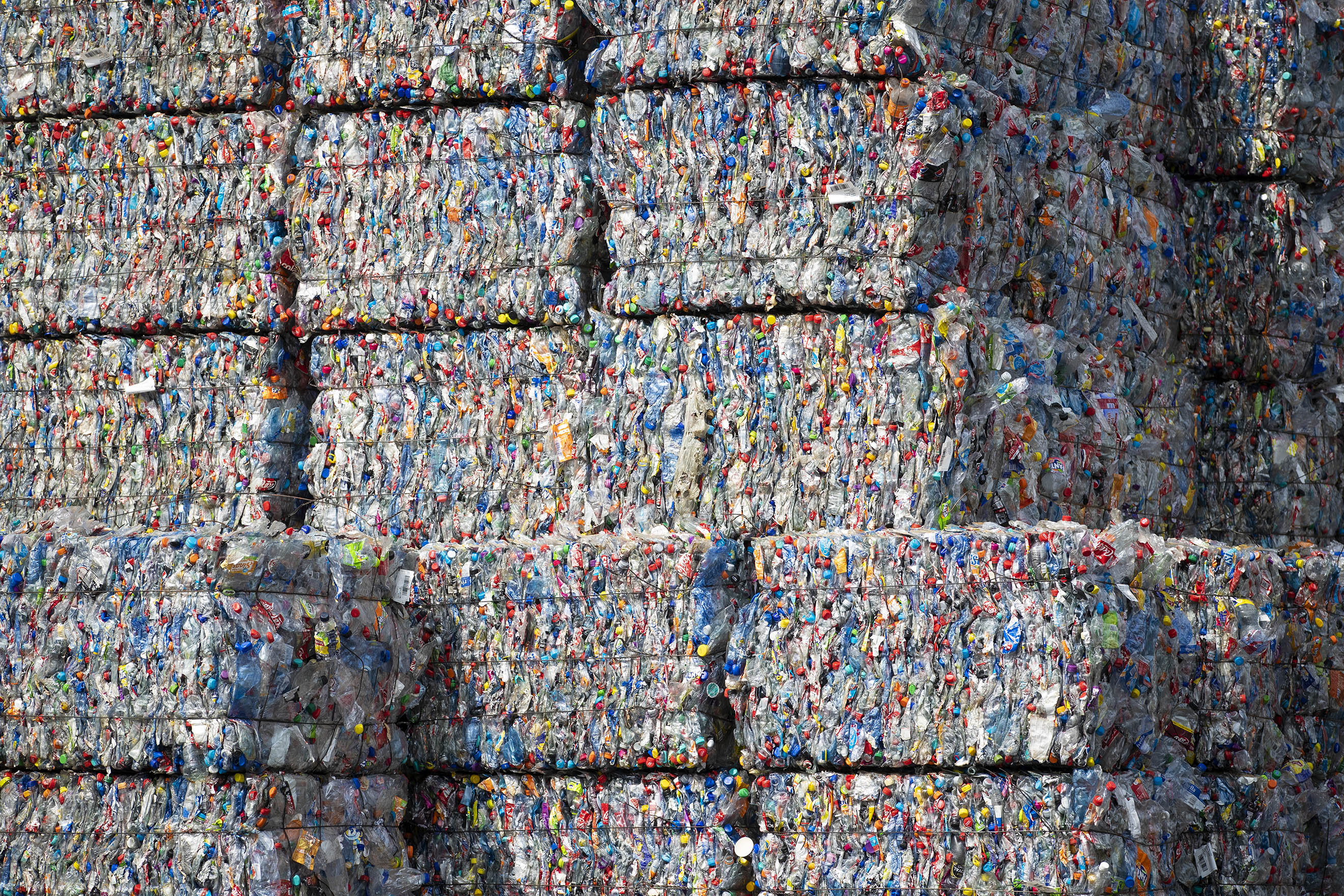 Bound bales of crushed plastic as part of developed countries exported wastewaiting to be recycled