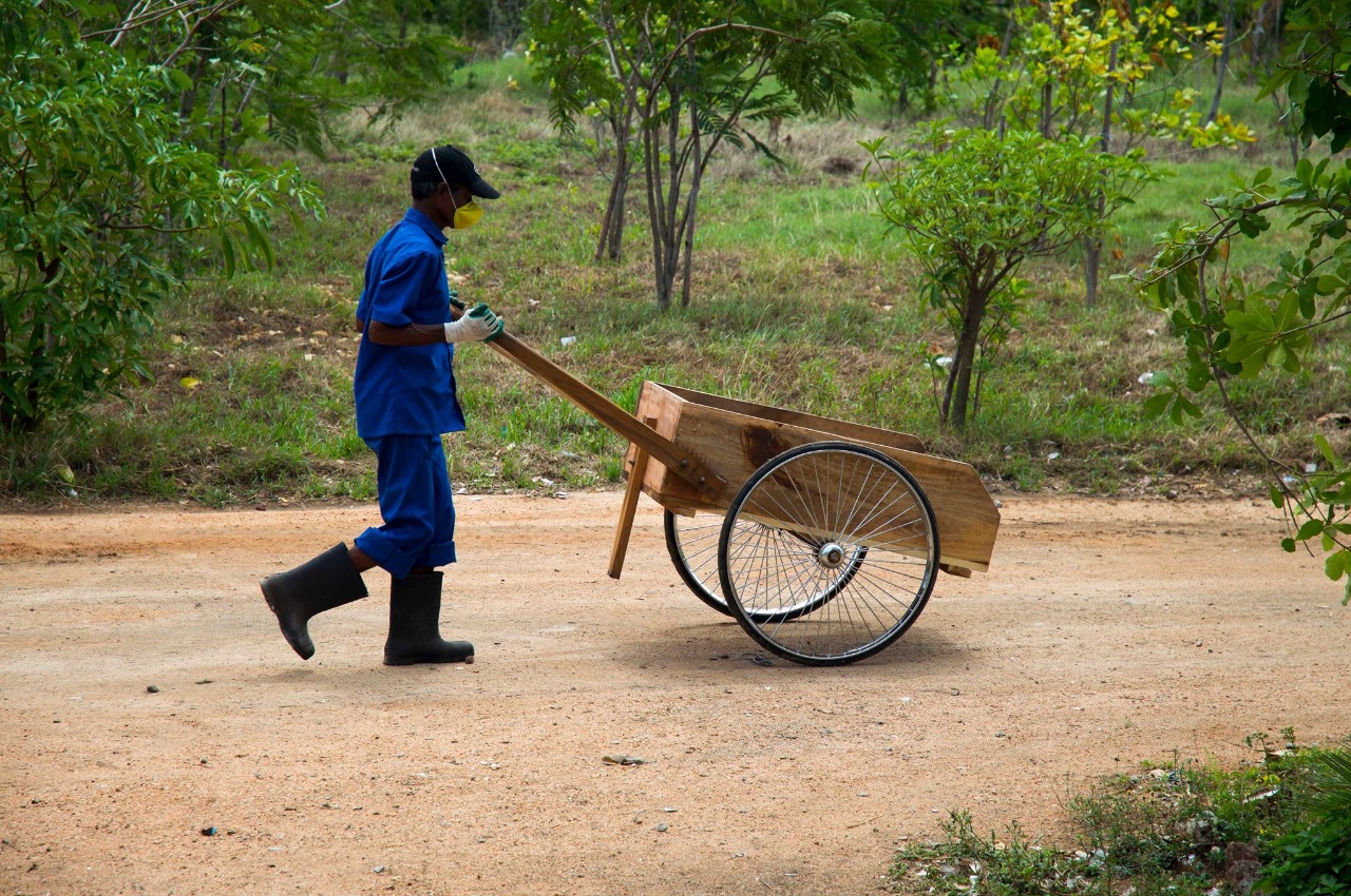 A waste worker from Waste Ventures India moving a wheel barrow
