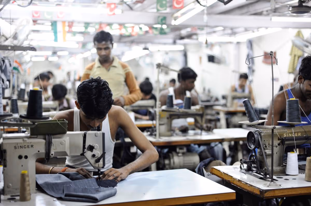 A man working in Dharavi, India to make clothes for the fast-fashion industry at minimum wage