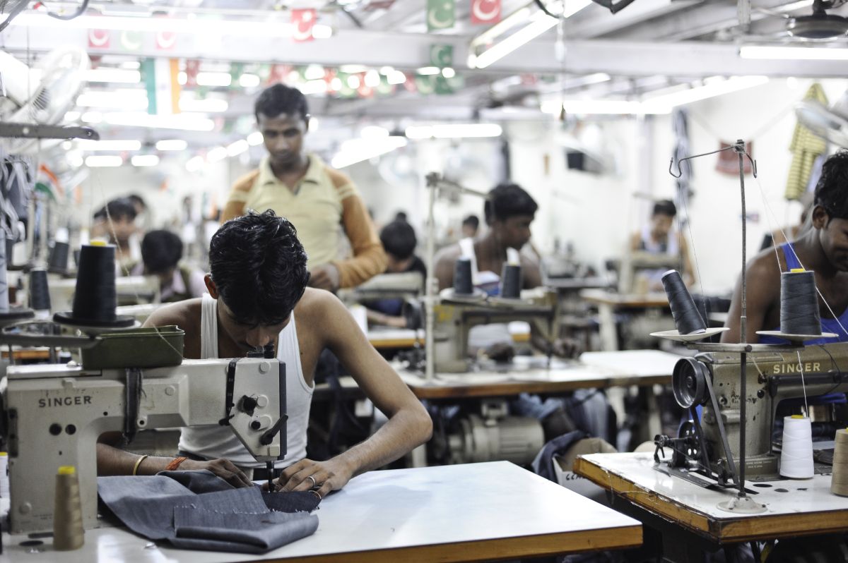 A man working in Dharavi, India to make clothes for the fast-fashion industry at minimum wage