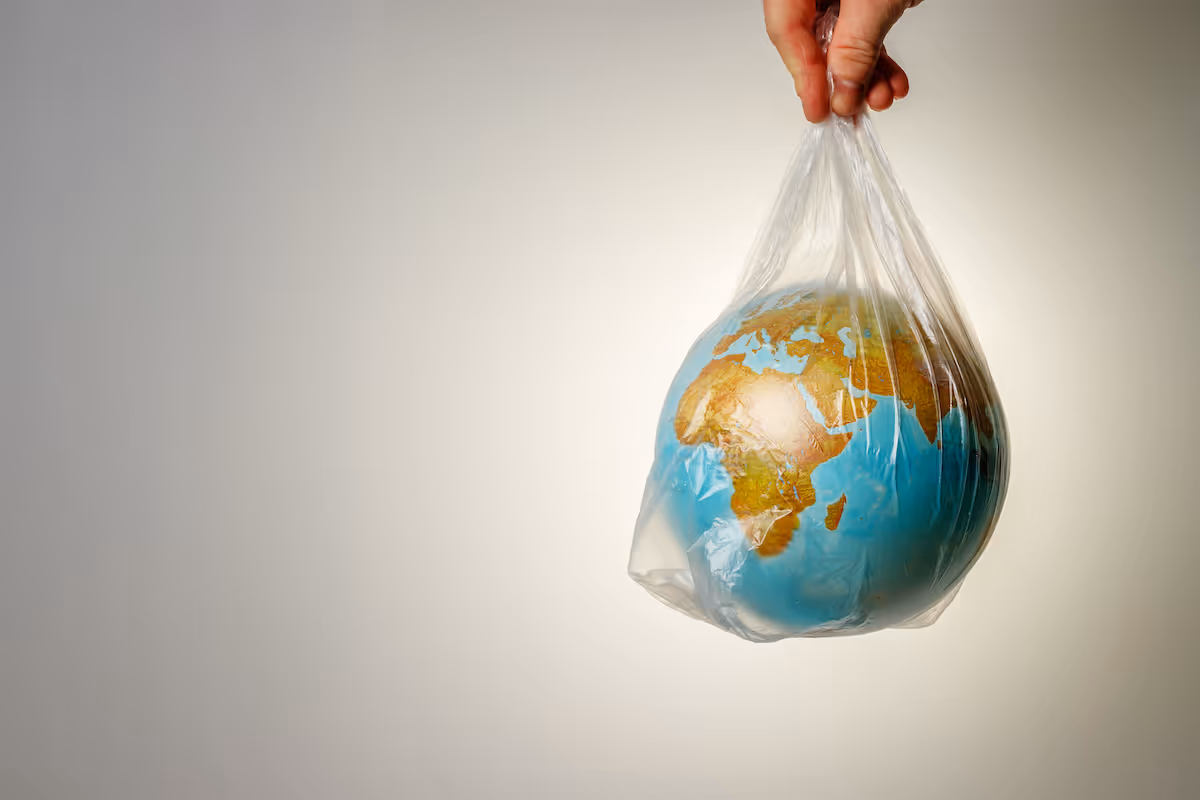 Image of a hand holding the earth in a plastic bag