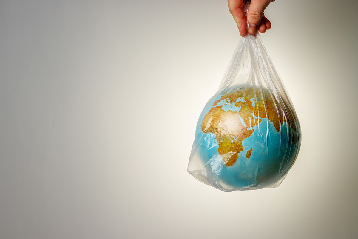 Image of a hand holding the earth in a plastic bag