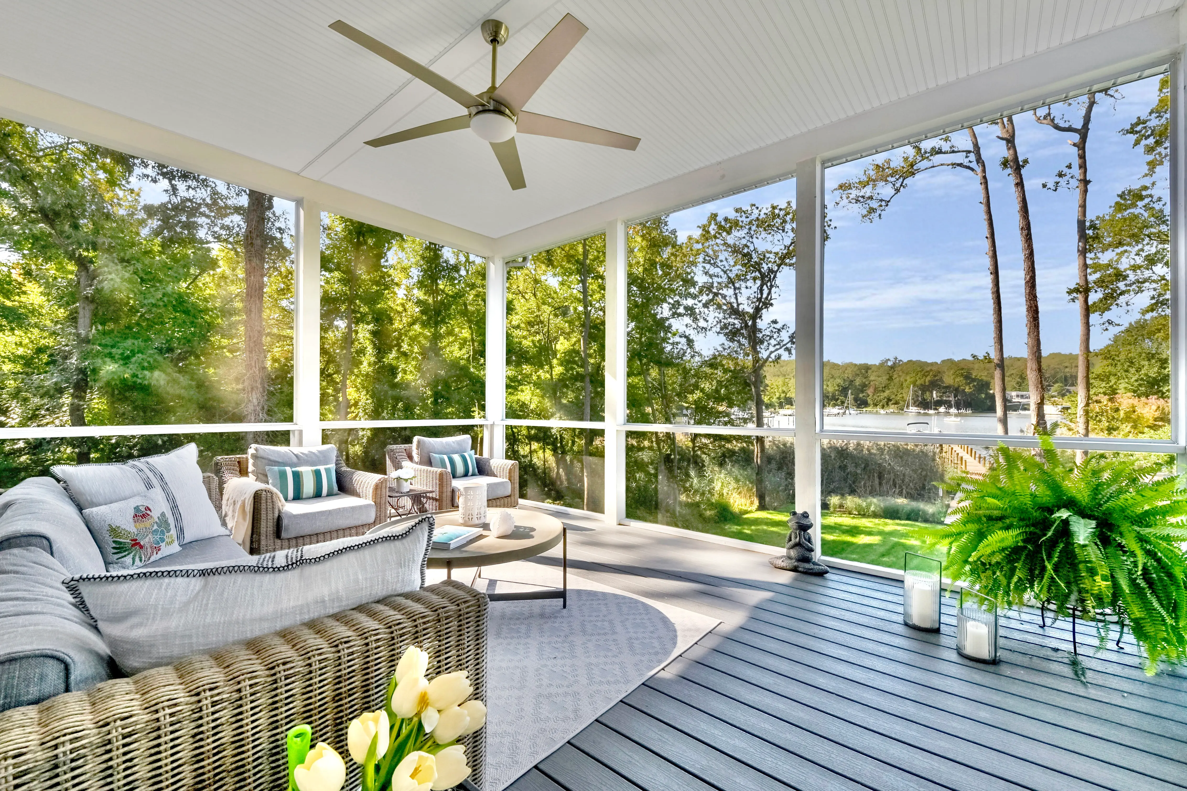 Furnished screened porch with ceiling fan and water view