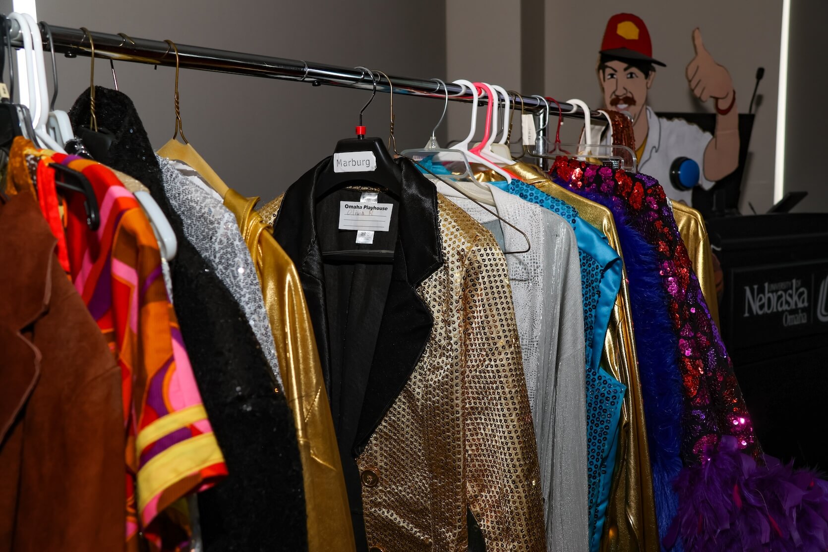 A rack of colorful funky clothing items (blazers and other tops) to serve as costumes for Risky Disco.