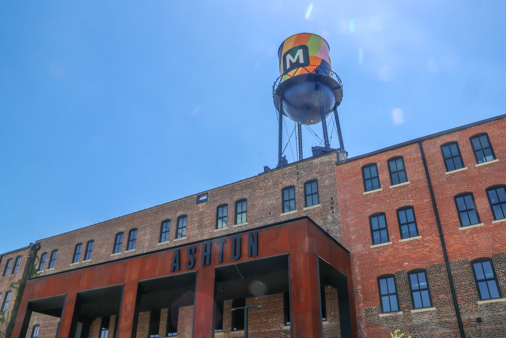 The outside of a large brick building that says “Ashton” in all black capital letters.