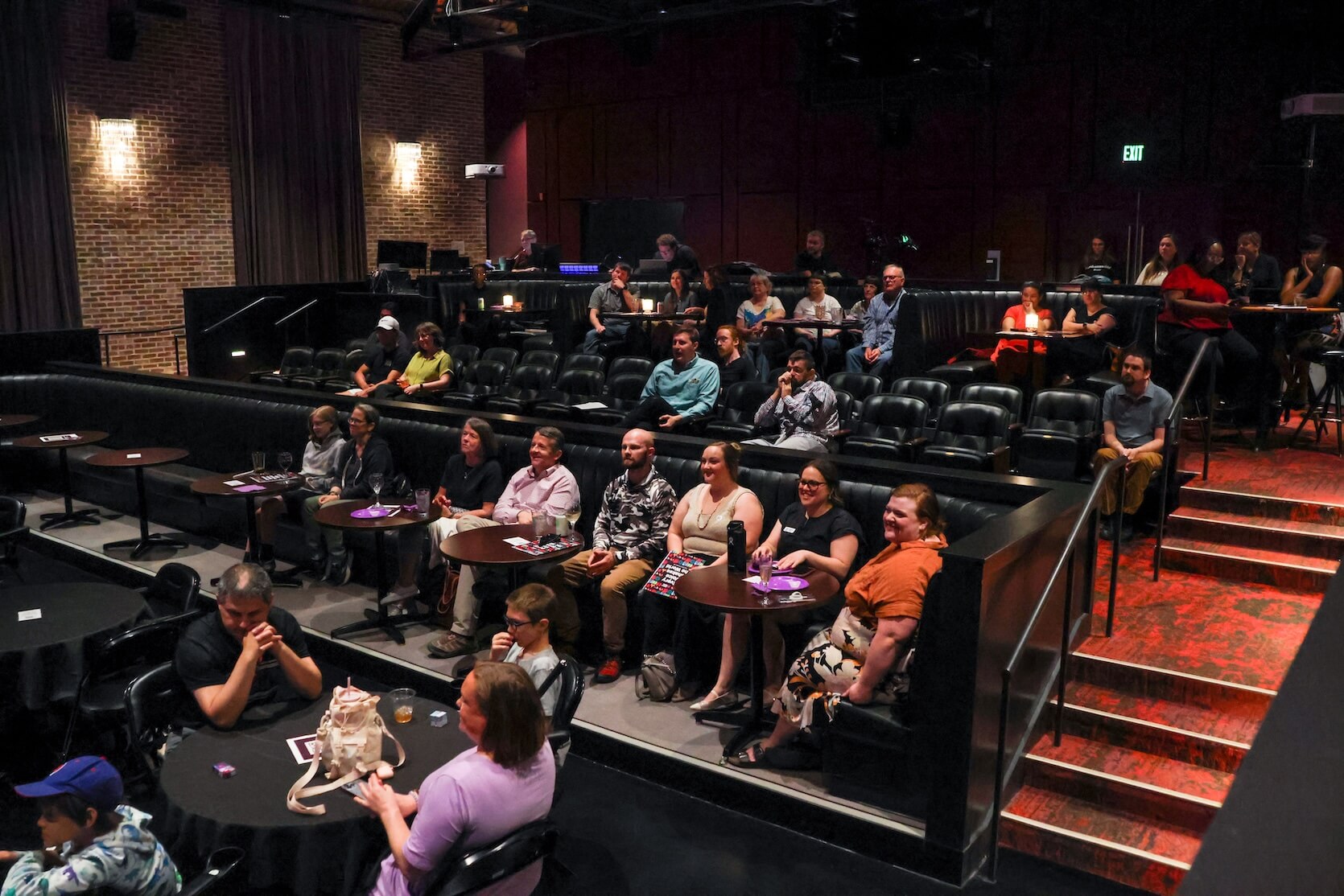 Many people are sitting in a theatre.