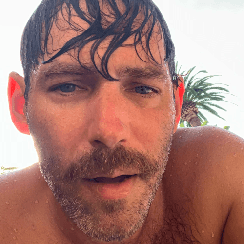 Darrin is a 46-year-old man with short brown hair and blue eyes. At 5’8” he is wearing short shorts and a sleeveless top along with white sneakers.
