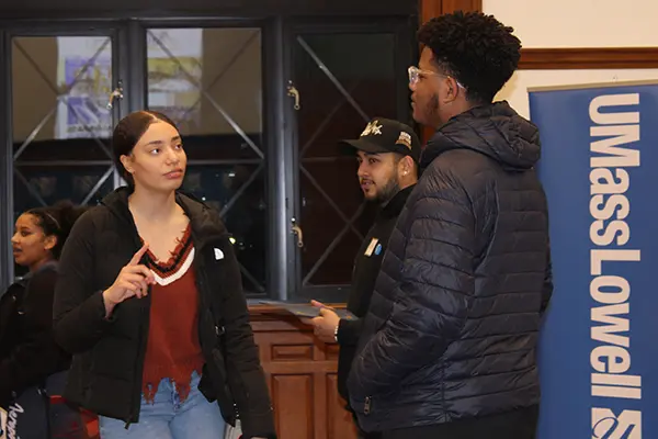 A young woman gestures with her hand while talking to a young man