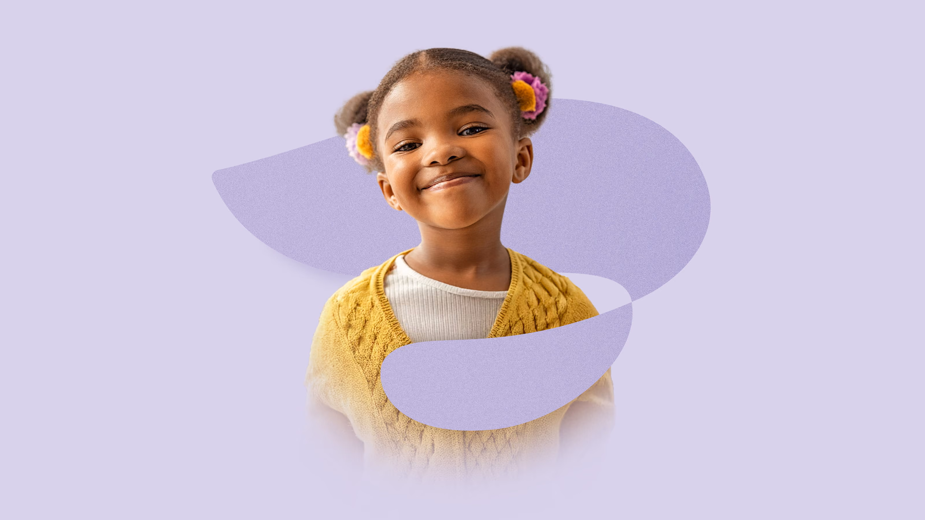 Smiling young girl with two puffs and flower clips wearing a yellow sweater on a purple background.