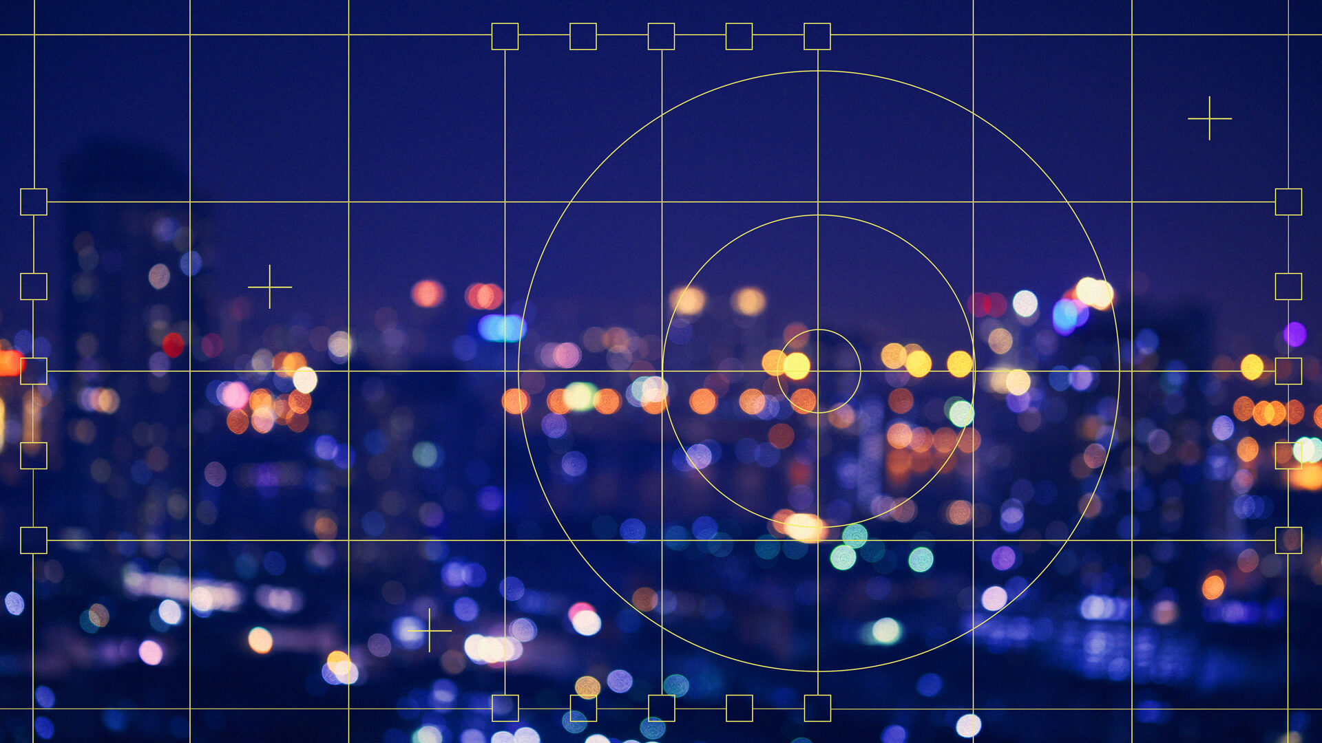 A cityscape at night with bright, colorful lights blurred into bokeh, overlaid with a grid and spirals to demonstrate the application of design principles such as symmetry and focus.