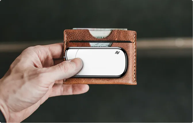 Powerland ultra-thin charger held in a hand next to a leather card wallet