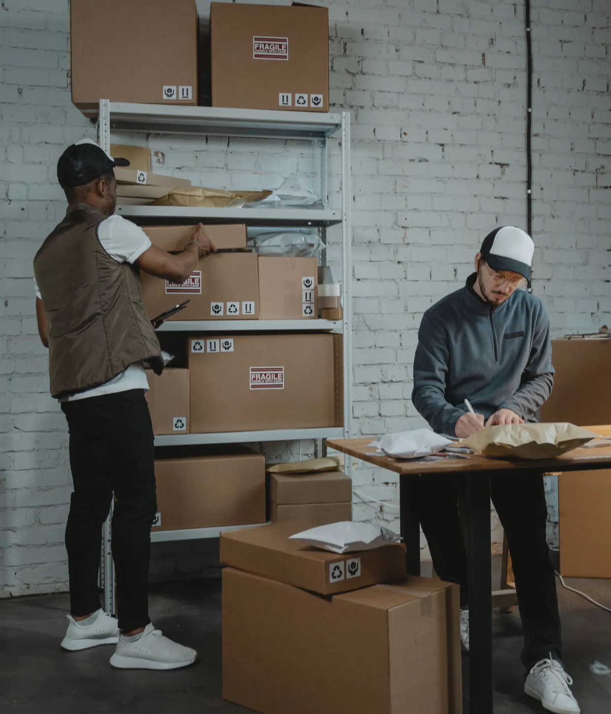 Two people packing and preparing product orders in a stockroom