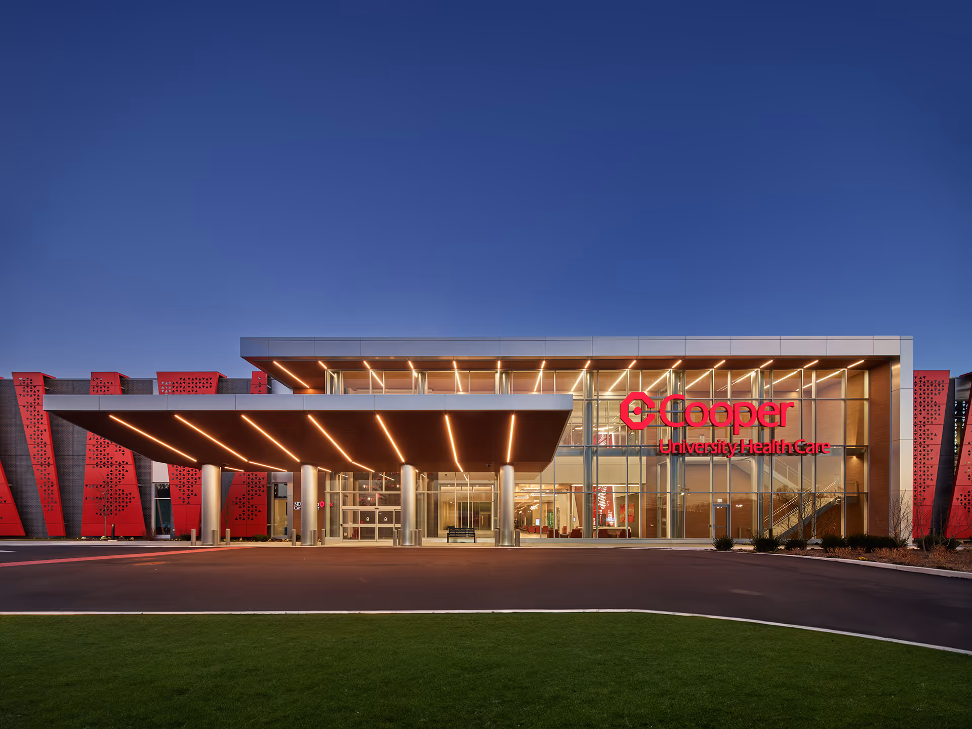 Modern healthcare facility entrance with illuminated glass facade.