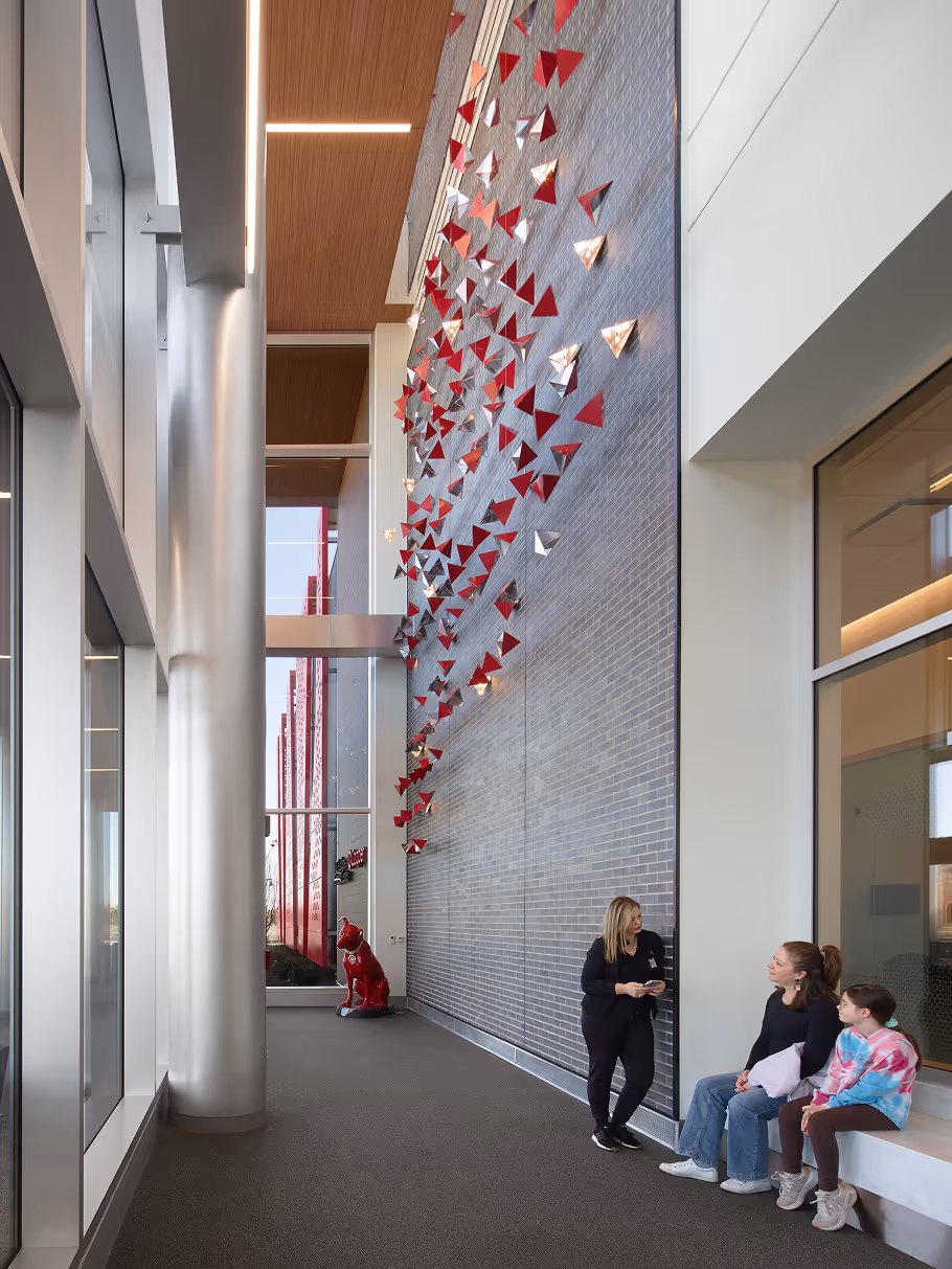 Modern interior hallway with geometric wall art and seating.
