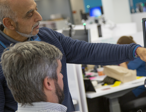 People reviewing a design on a computer screen.
