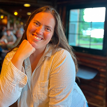 Smiling woman seated at a restaurant table.