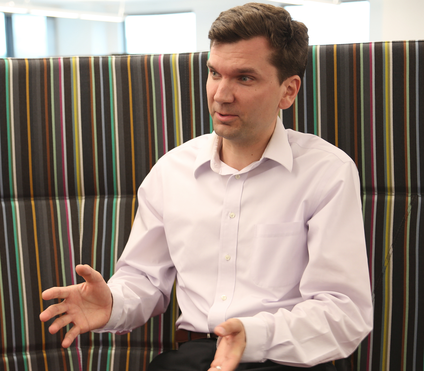 Team member speaking during a meeting in a collaborative office space.